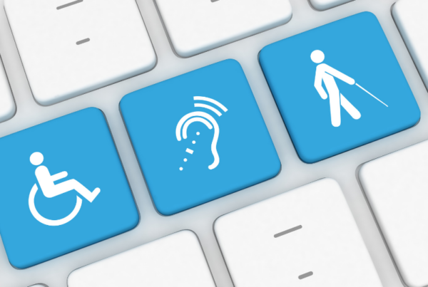 Þrír bláir aðgengislyklar á tölvulyklaborði sem sýna tákn fyrir hjólastól, heyrn/textun og blindrastaf.